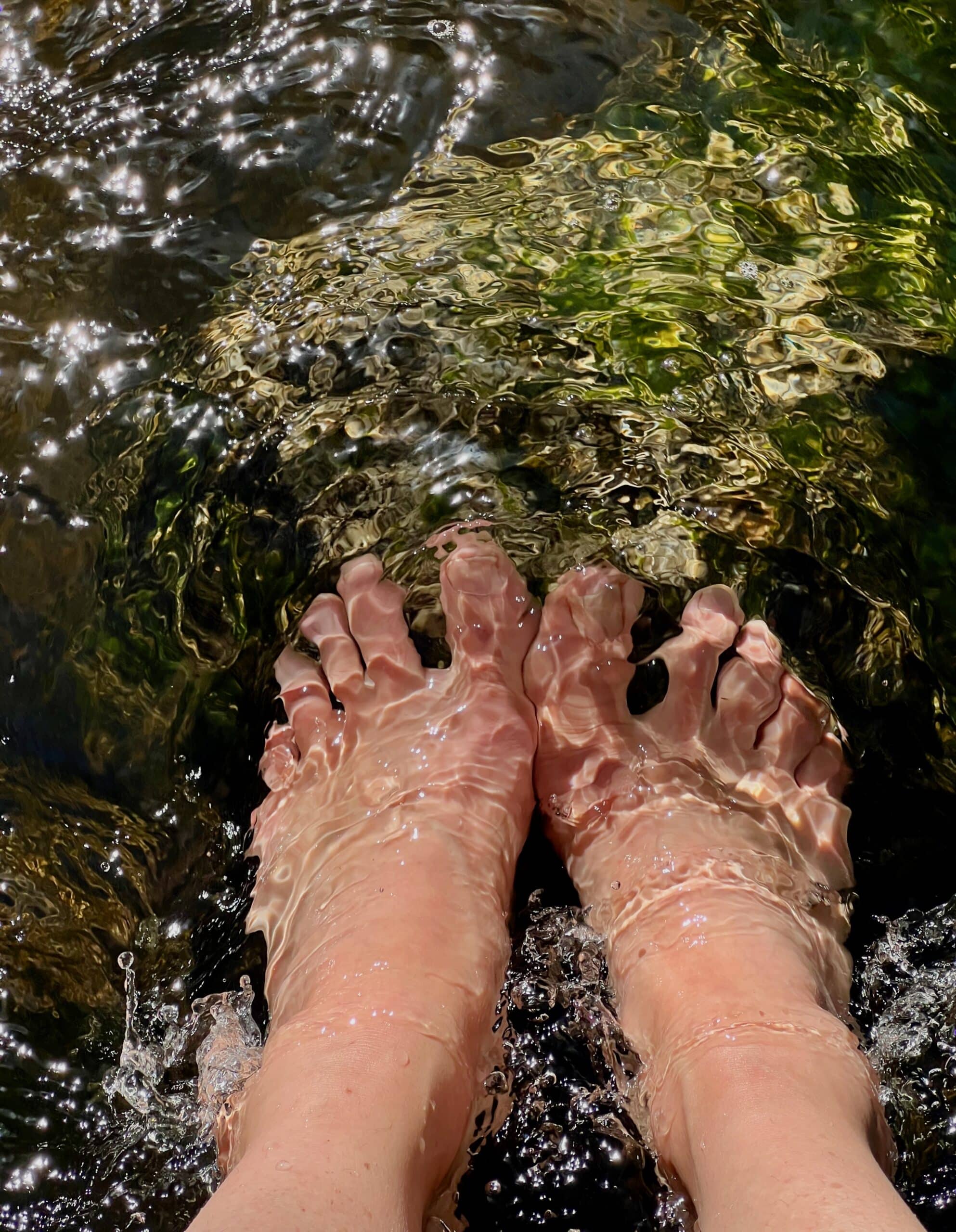barefeet in a flowing stream - slowing down, connecting with yourself in nature, and feeling relaxed